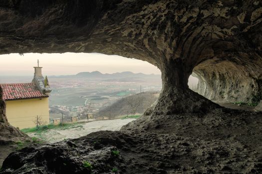 A stunning view from a cave opening in Villaga, Italy, overlooking the countryside.