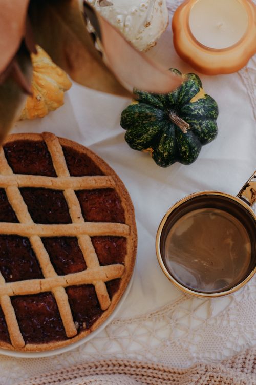 Free Warm autumn scene with pie, coffee, and decorative gourds on a cozy table. Stock Photo