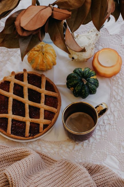 Top view of a cozy autumn setting with pumpkin pie, coffee, and decorative pumpkins.