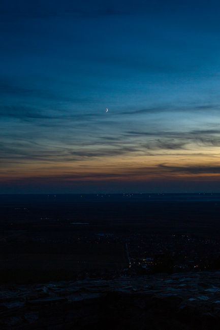 Serene view of Vršac, Serbia at twilight with a crescent moon and colorful sky backdrop.