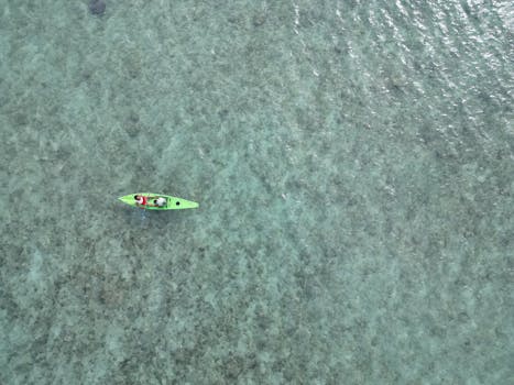 Aerial shot of a kayak in the clear ocean waters of West Nusa Tenggara, Indonesia.