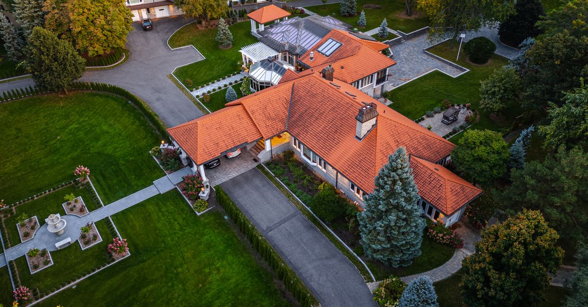 Drone shot capturing a luxurious estate with orange roof in Saint-Jean-sur-Richelieu, Canada.