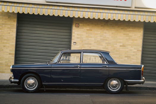 Classic blue sedan car parked beside a brick building in the city, showcasing urban vintage style.