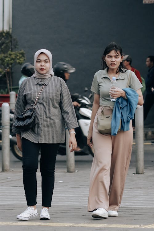 Women Walking on Pavement in City