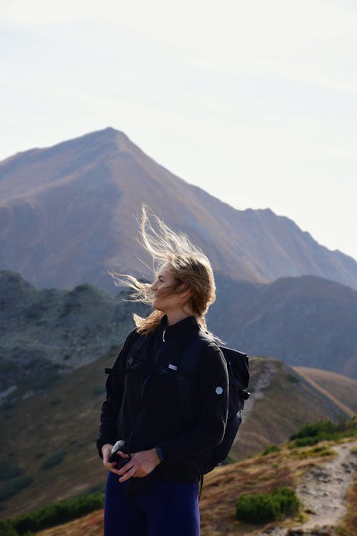 Woman in Black Jacket on Trail Near Mountain