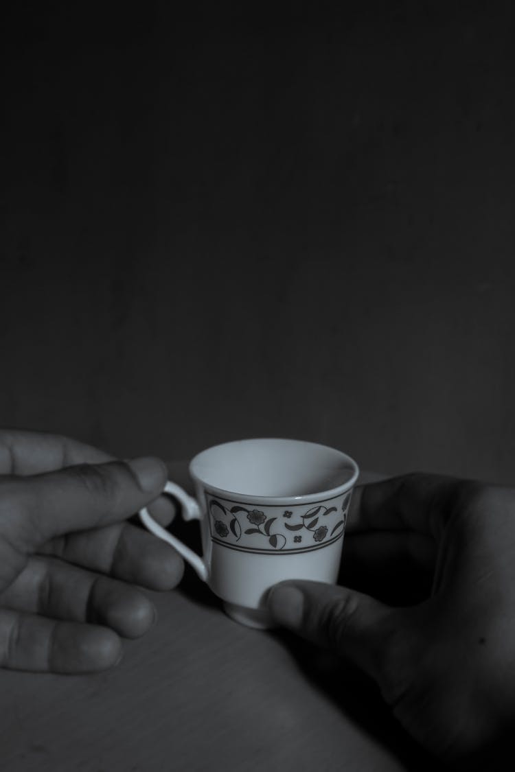 Hands Of A Person Holding A Cup