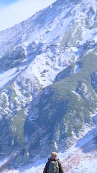 An adventurer with a backpack explores snowy mountains in Toyama, Japan.