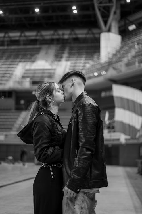 Young Man and Woman Kissing at a Stadium