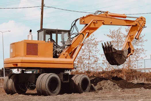 A yellow excavator at a rural construction site, ready for operation.