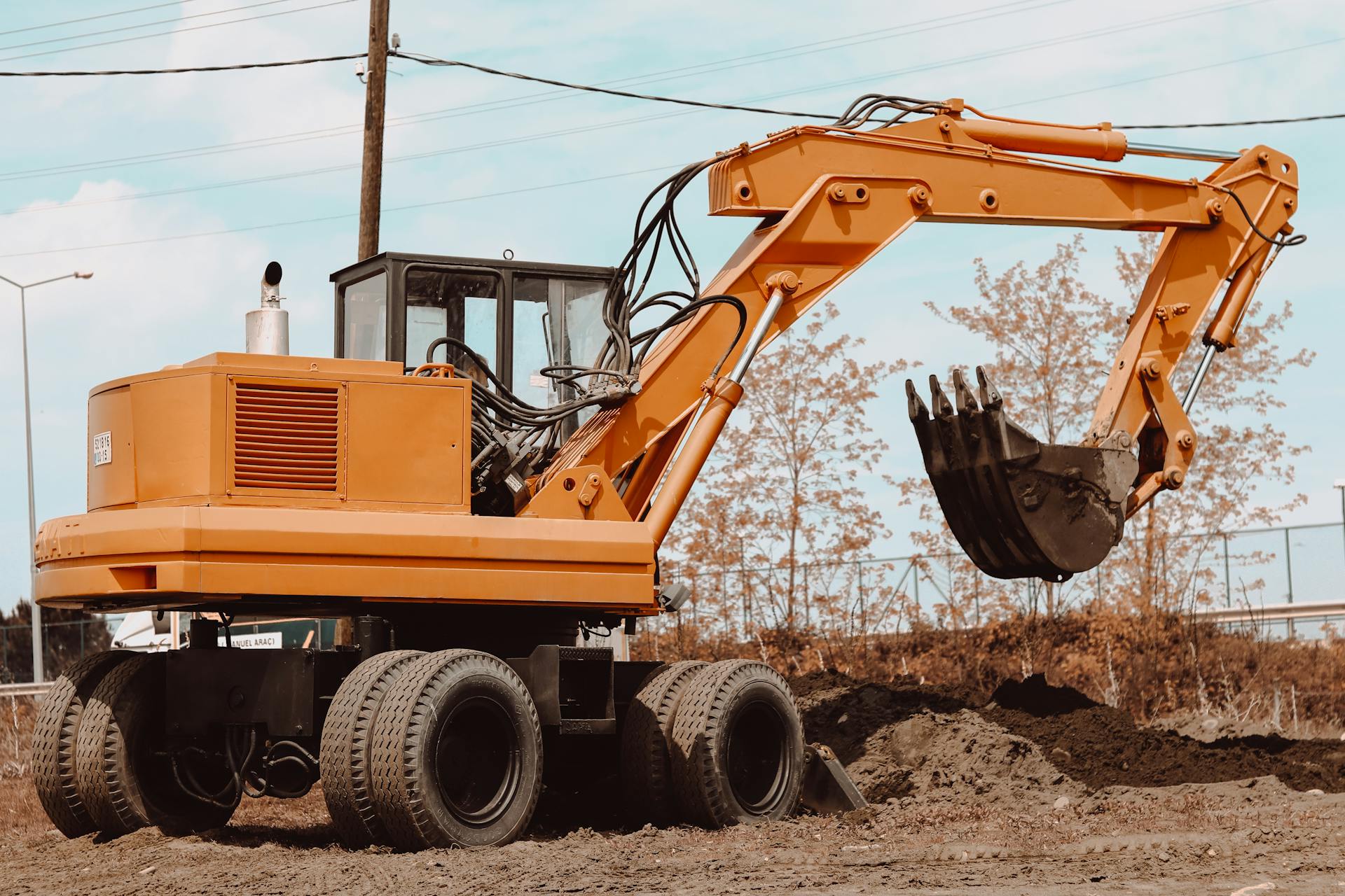 A yellow excavator at a rural construction site, ready for operation.