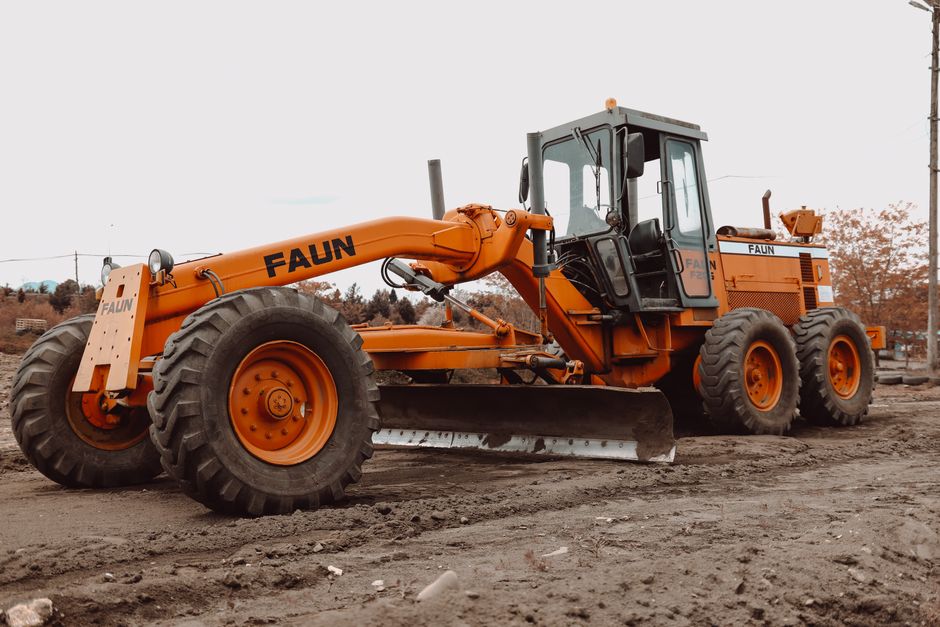 heavy grader leveling soil on a commercial site heavy grader leveling soil on a commercial site