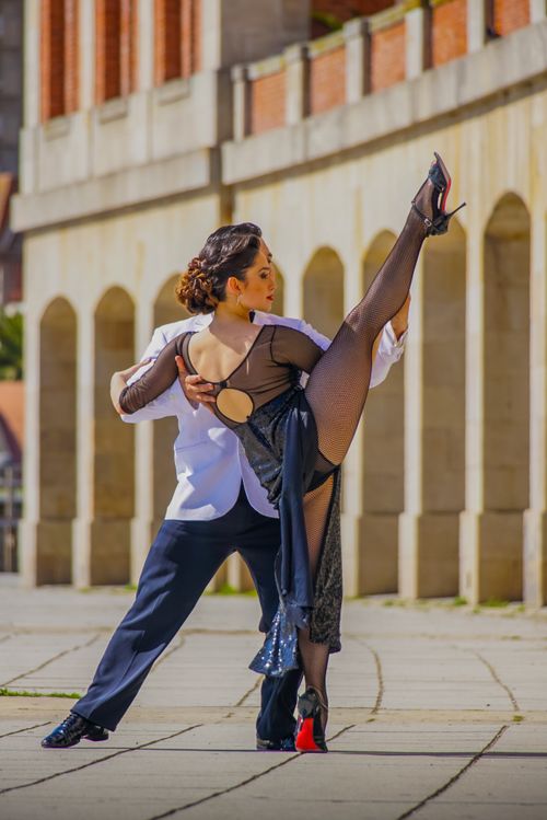 Free A graceful dance couple in an outdoor setting showcasing a stunning dance pose against a classic architectural backdrop. Stock Photo