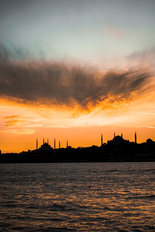 Free Silhouette of Istanbul's skyline at sunset, featuring minarets and dramatic skies over the Bosporus Strait. Stock Photo