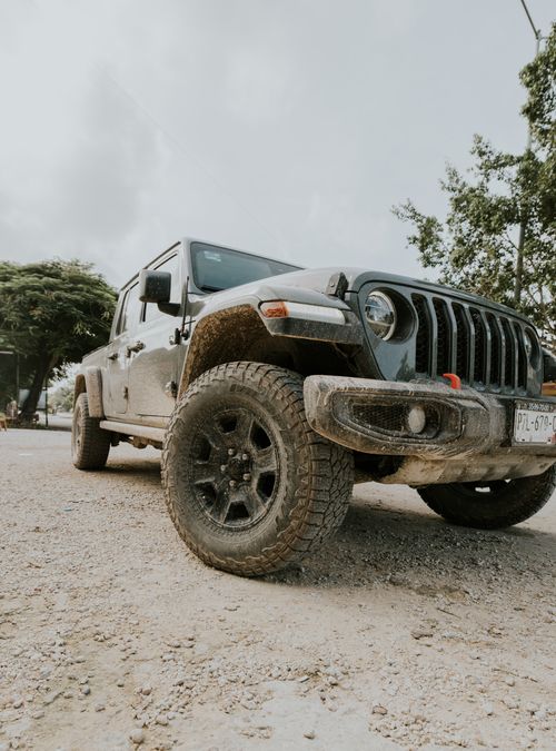 Free A rugged Jeep showcasing durability parked on a dirt road, perfect for adventure enthusiasts. Stock Photo