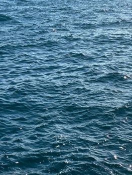 A serene view of the ocean waves under sunlight, capturing the natural texture and pattern.