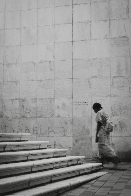 Woman Walking near Stairs and Wall