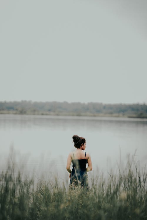 Brunette Woman in Dress Standing on Lakeshore