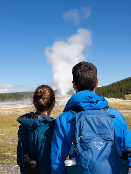 Couple Watching a Geyser Erupt in Yellowstone National Park