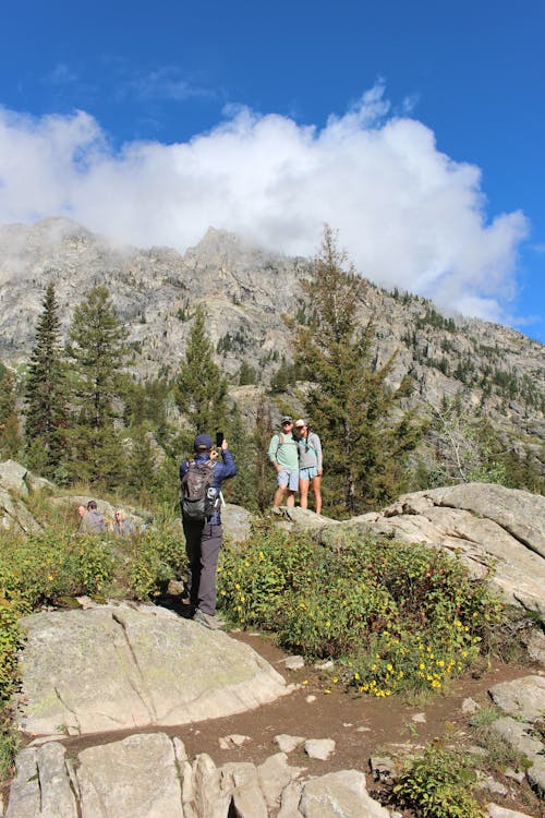 Hikers Taking Photos with Rocky Mountains in the Background