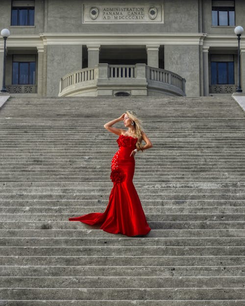 Woman Wearing Red Dress Posing on Stairs 