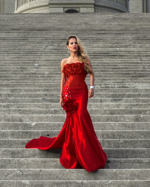 Elegant Model in Red Dress Posing on Stairs
