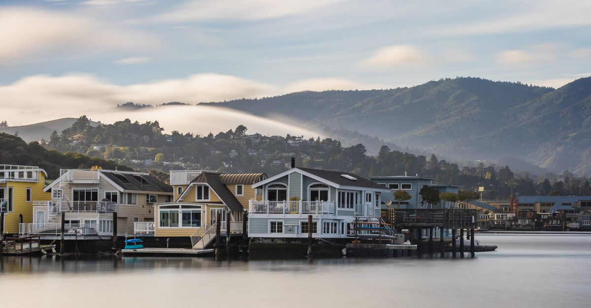 Charming houseboats in Sausalito with a serene mountain backdrop during sunrise.