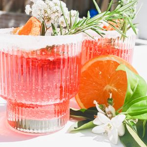 Red citrus cooler over ice with a blood-orange slice — photo by Studio Naae on Pexels