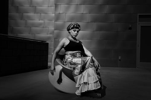 Model in Skirt Sitting on Chair in Black and White