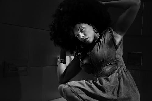 Brunette Woman with Afro Hairdo Posing in Denim Dress
