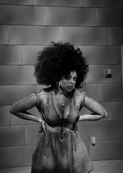 Black and White Photo of a Curly Haired Woman Posing in Denim Dress