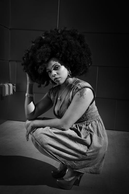 Woman with Afro Squatting and Posing in Dress