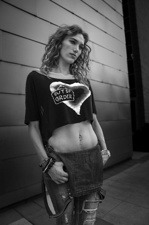 Black and White Photo of a Woman in Cropped T-Shirt and Denim Overalls