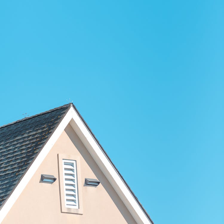 Pitched Roof of a House against a Clear Blue Sky