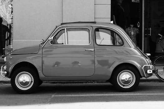 Vintage Fiat 500 parked on an Italian city street, showcasing classic automotive style.