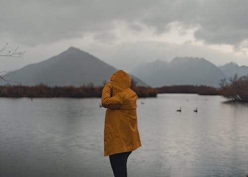 Woman Wearing Raincoat by the Lake 