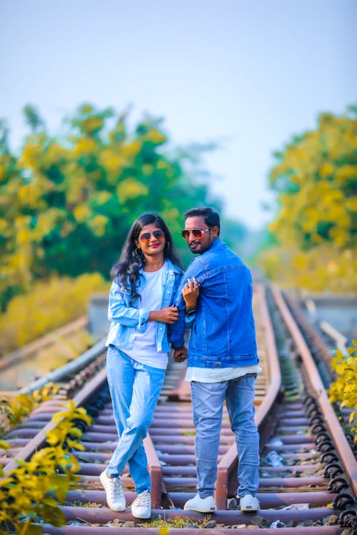 Couple in Denim Jackets Posing on Railway Tracks