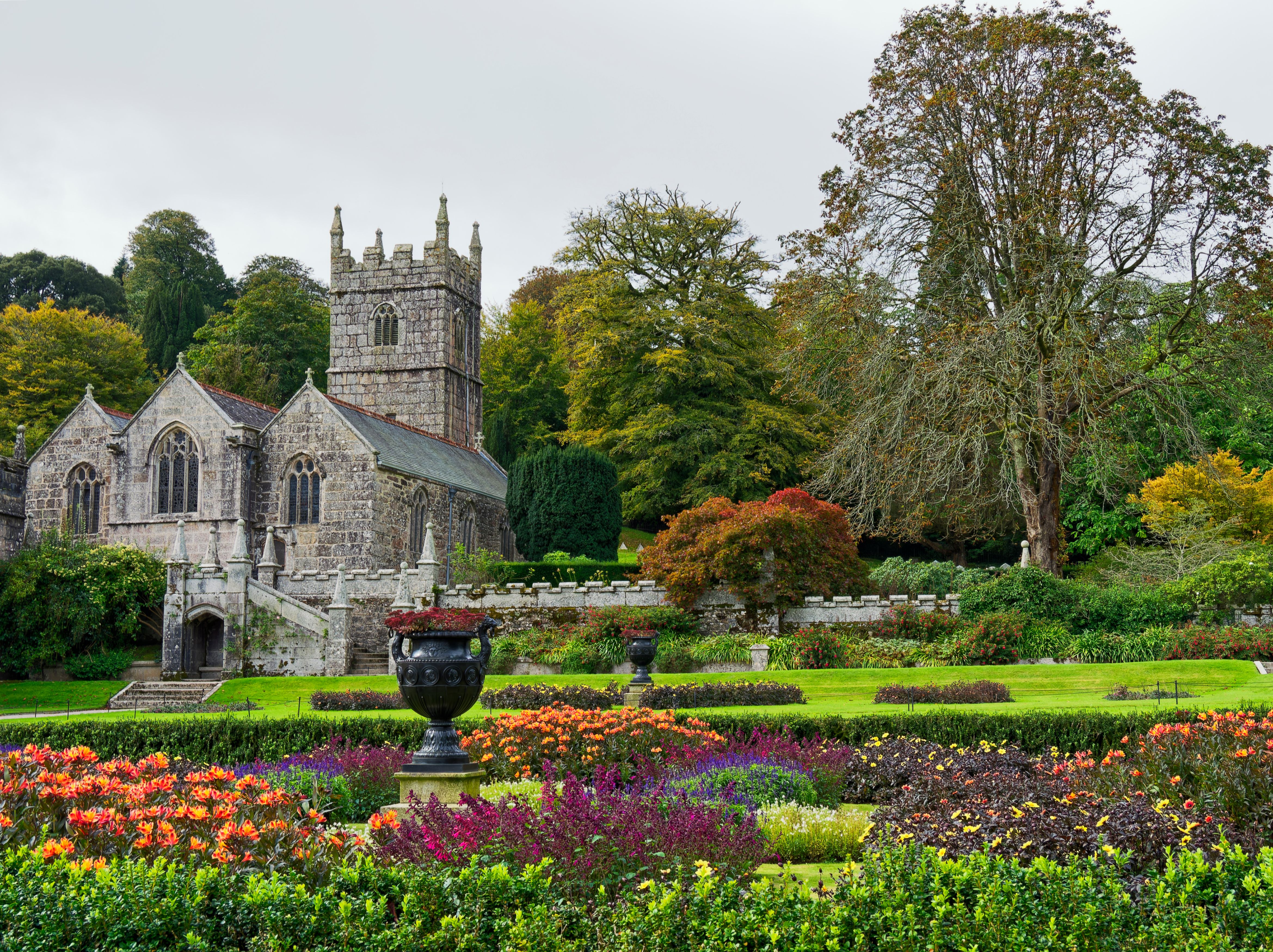 Beautiful English church surrounded by a lush, colorful garden and autumn trees.
