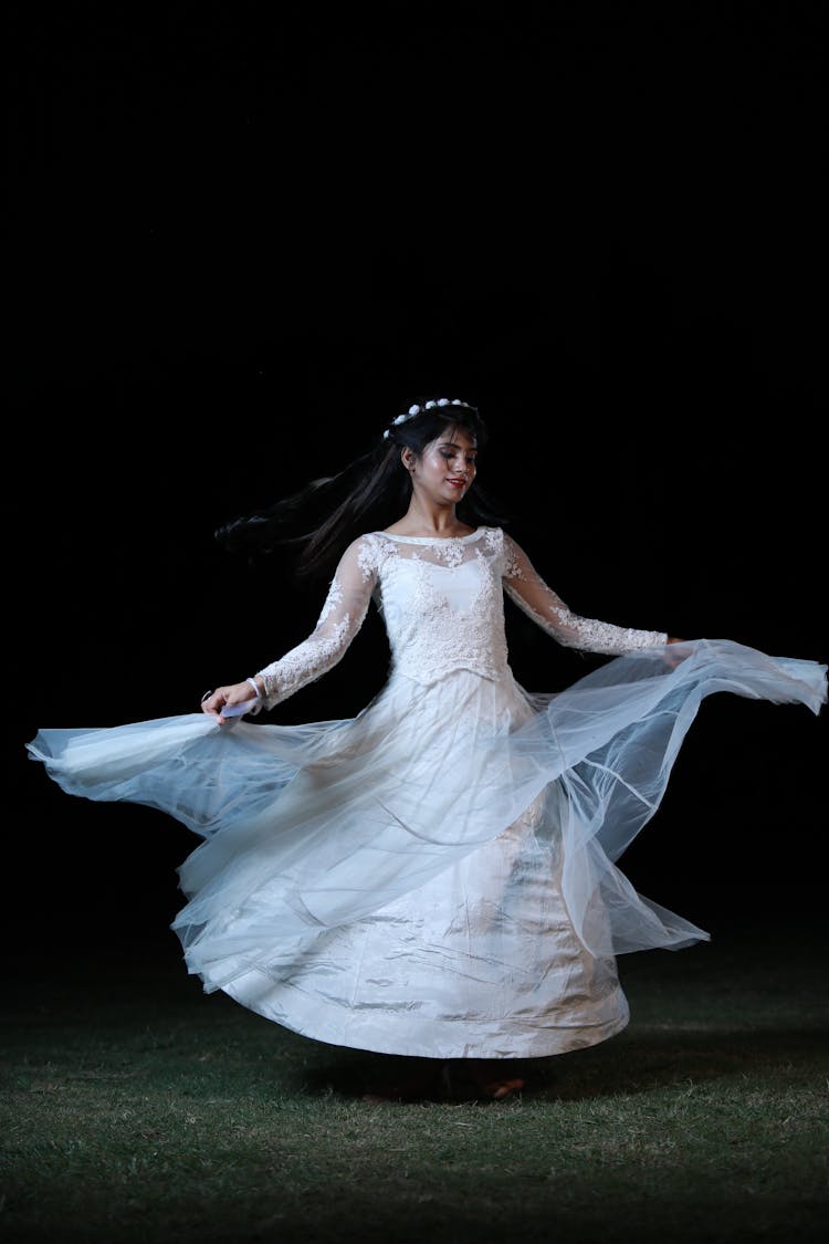 Woman Dancing In White Dress On A Stage 