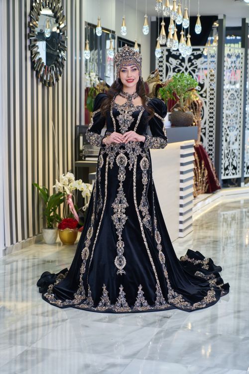Free An elegant woman posing in a luxurious traditional Turkish dress indoors, showcasing intricate design. Stock Photo