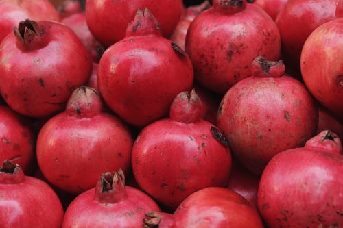 Free Freshly harvested pomegranates on display at an outdoor market in Palermo, Sicily, Italy. Stock Photo