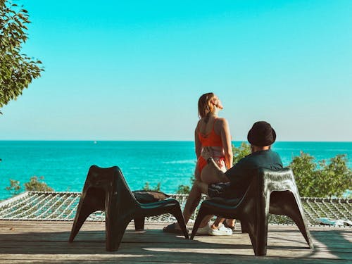 Couple of Tourists Sitting on the Terrace Overlooking the Sea