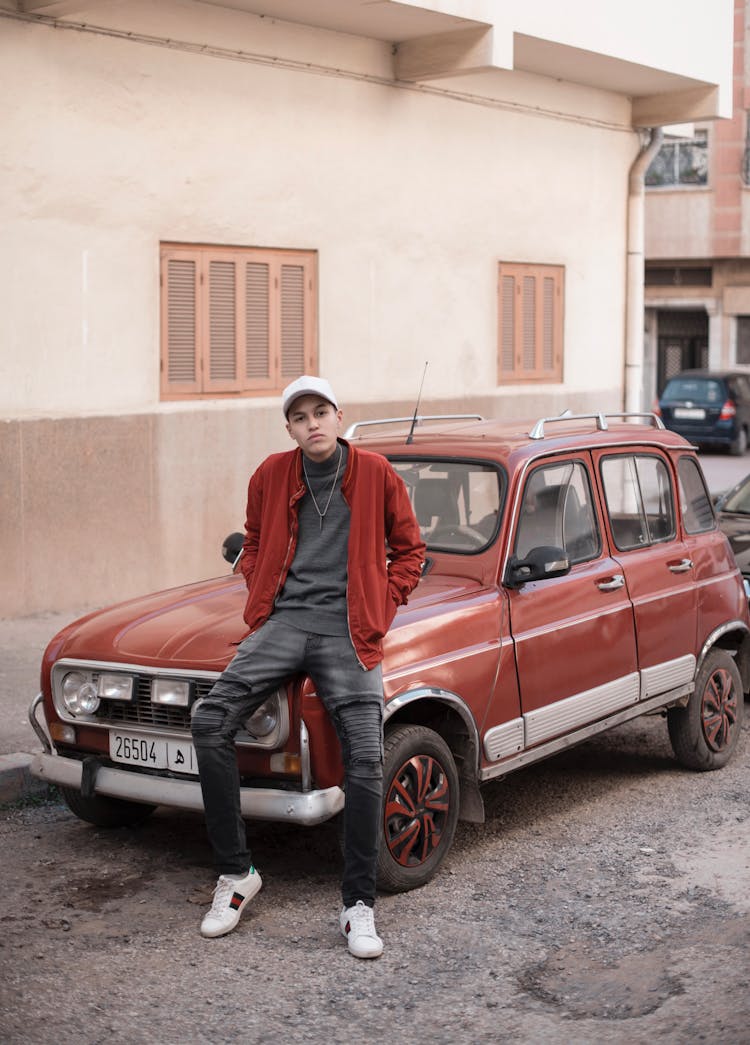 Young Man On Hood Of Red Old Car