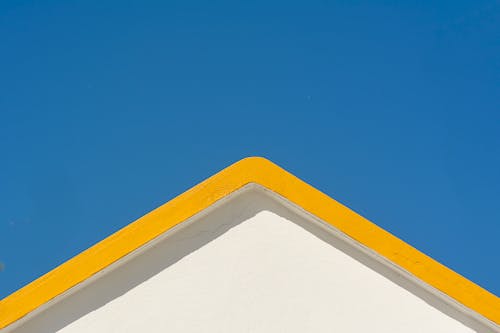 Yellow Roof Line of White House Wall against Clear Blue Sky