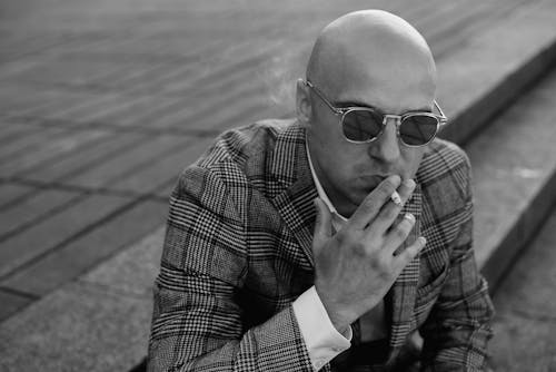 Bald Man in Sunglasses Smoking Cigarette