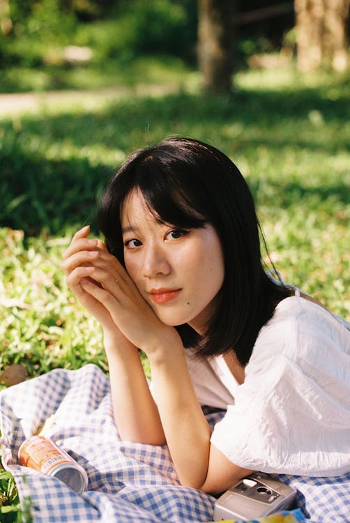 Young Woman Lying on a Picnic Blanket