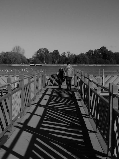 People on Boardwalk with Lake behind in Black and White