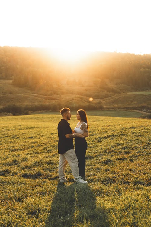 Couple Standing on Grassland at Sunset