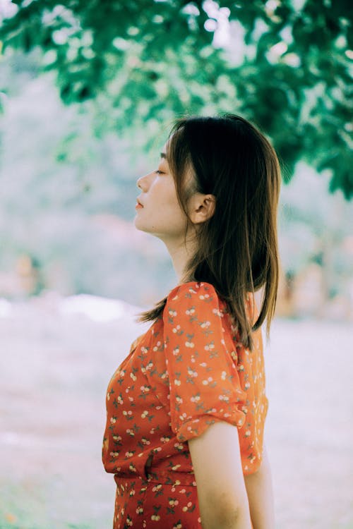 Woman in Red Sundress Standing with Eyes Closed