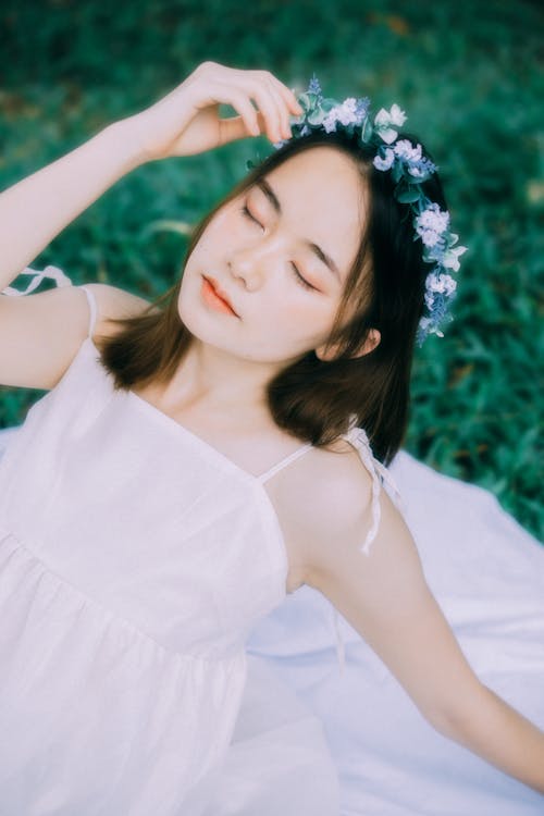 Young Model in a White Summer Dress and Garland on a Picnic