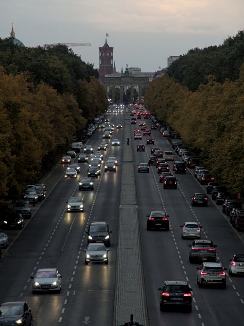 Free Aerial view of busy Berlin street with cars and iconic skyline in evening light. Stock Photo